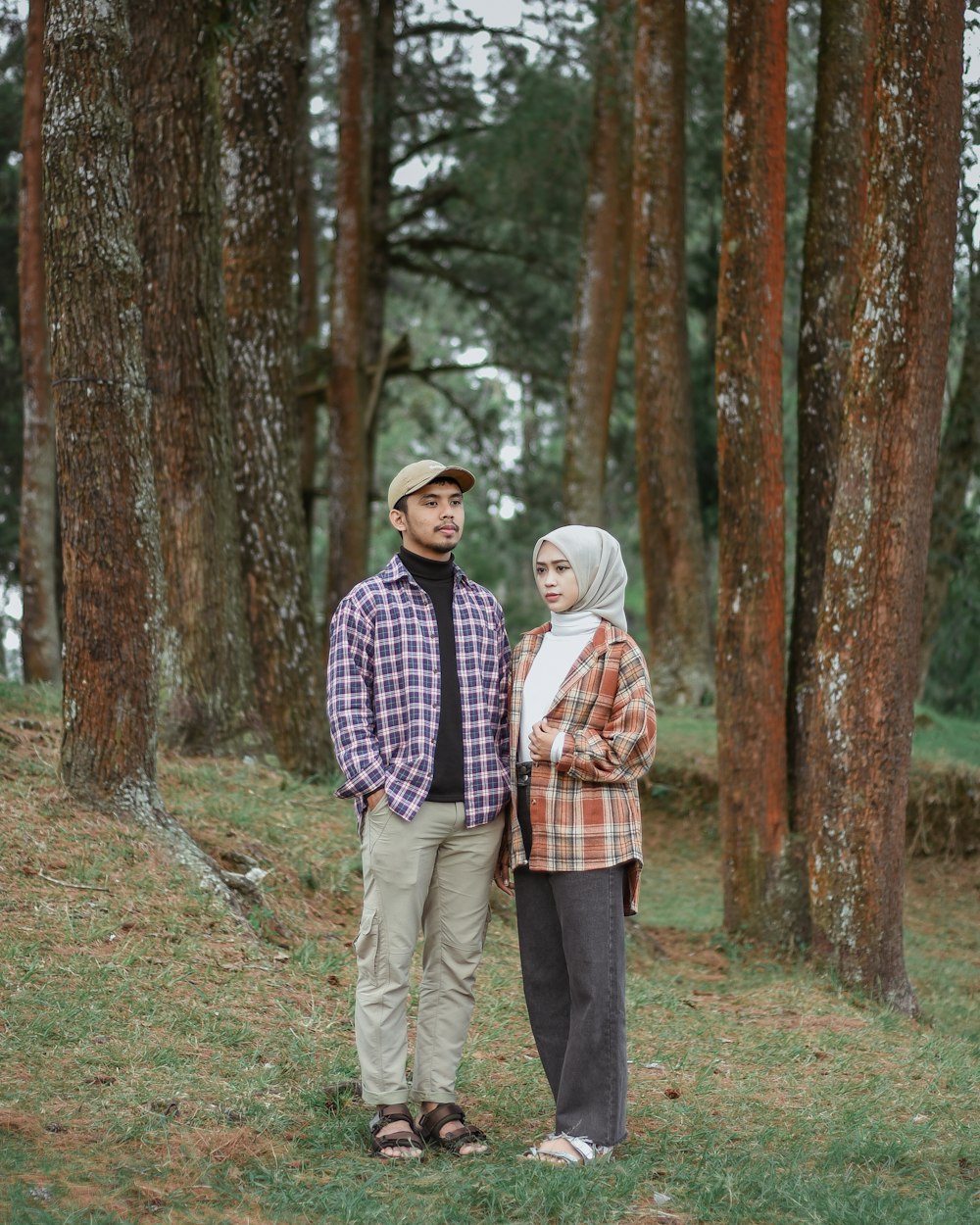 um homem e uma mulher de pé na floresta
