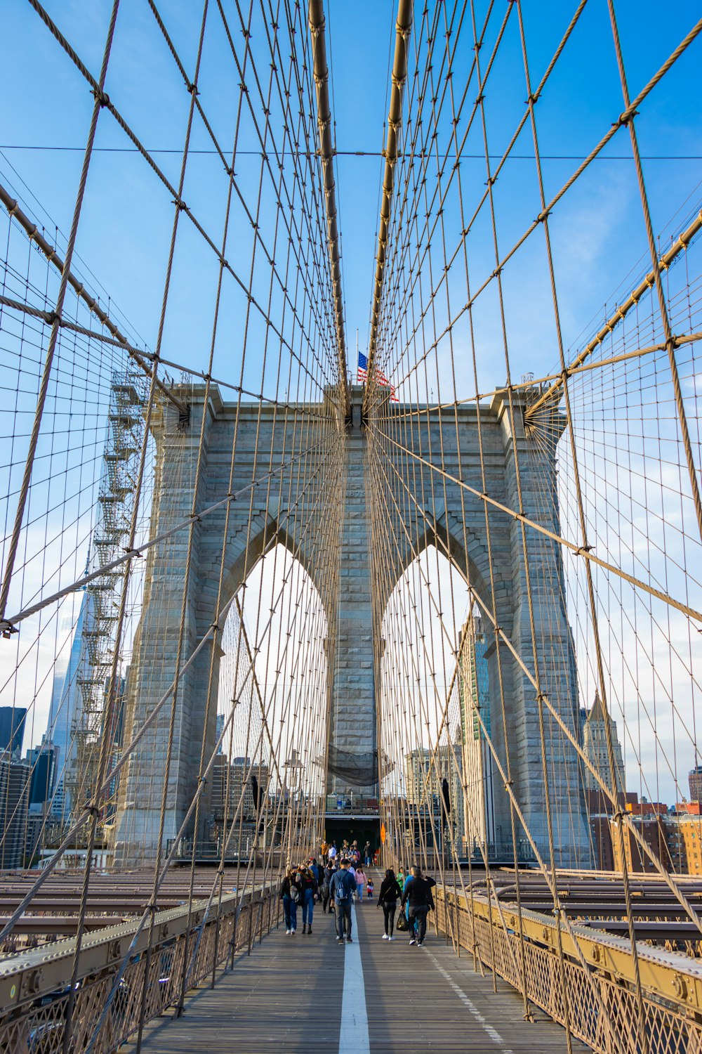 a group of people walking across a bridge