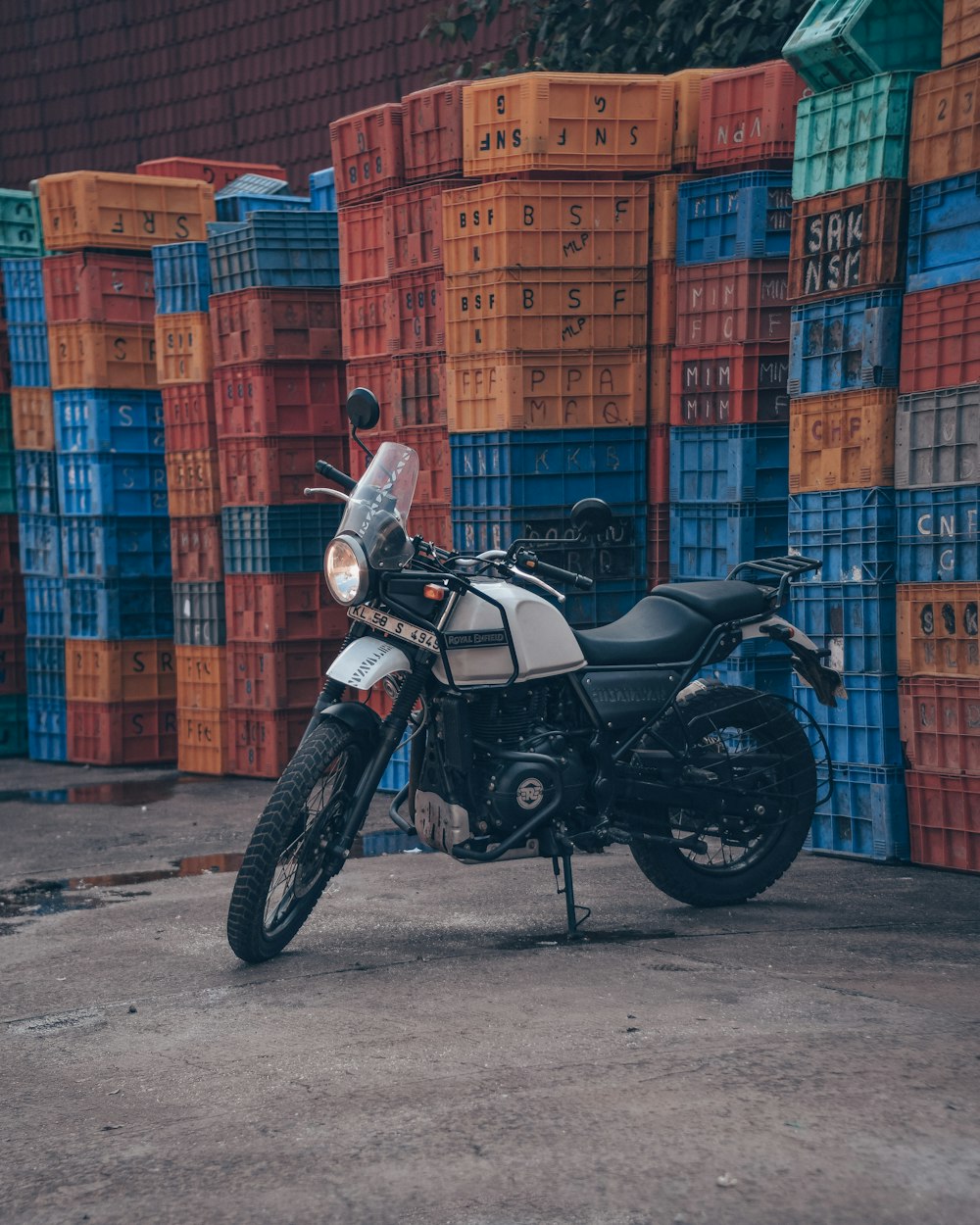 a black and white motorcycle parked in front of stacks of crates