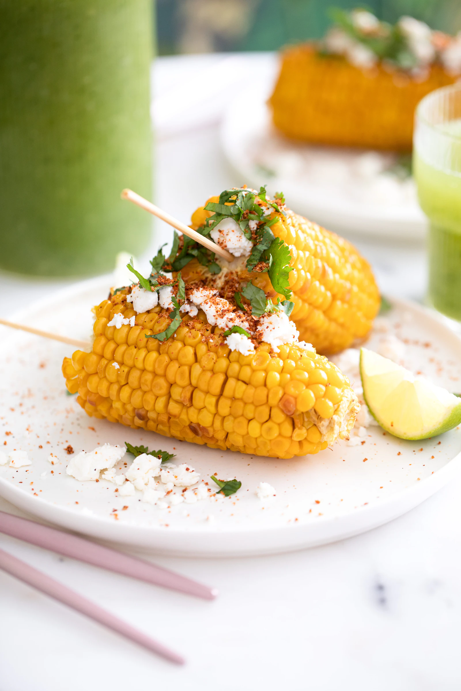 Mexican street corn on the cob topped with cotija cheese, chili powder, and cilantro