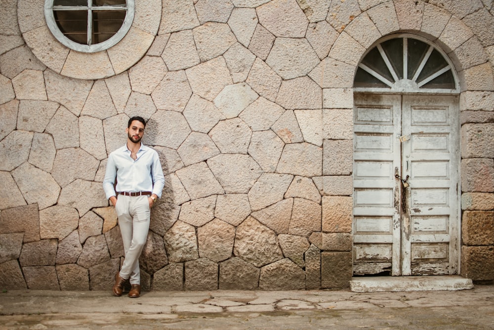 a man standing in front of a stone building