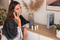 a woman sitting on a counter talking on a cell phone