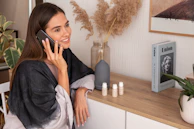 a woman sitting on a counter talking on a cell phone