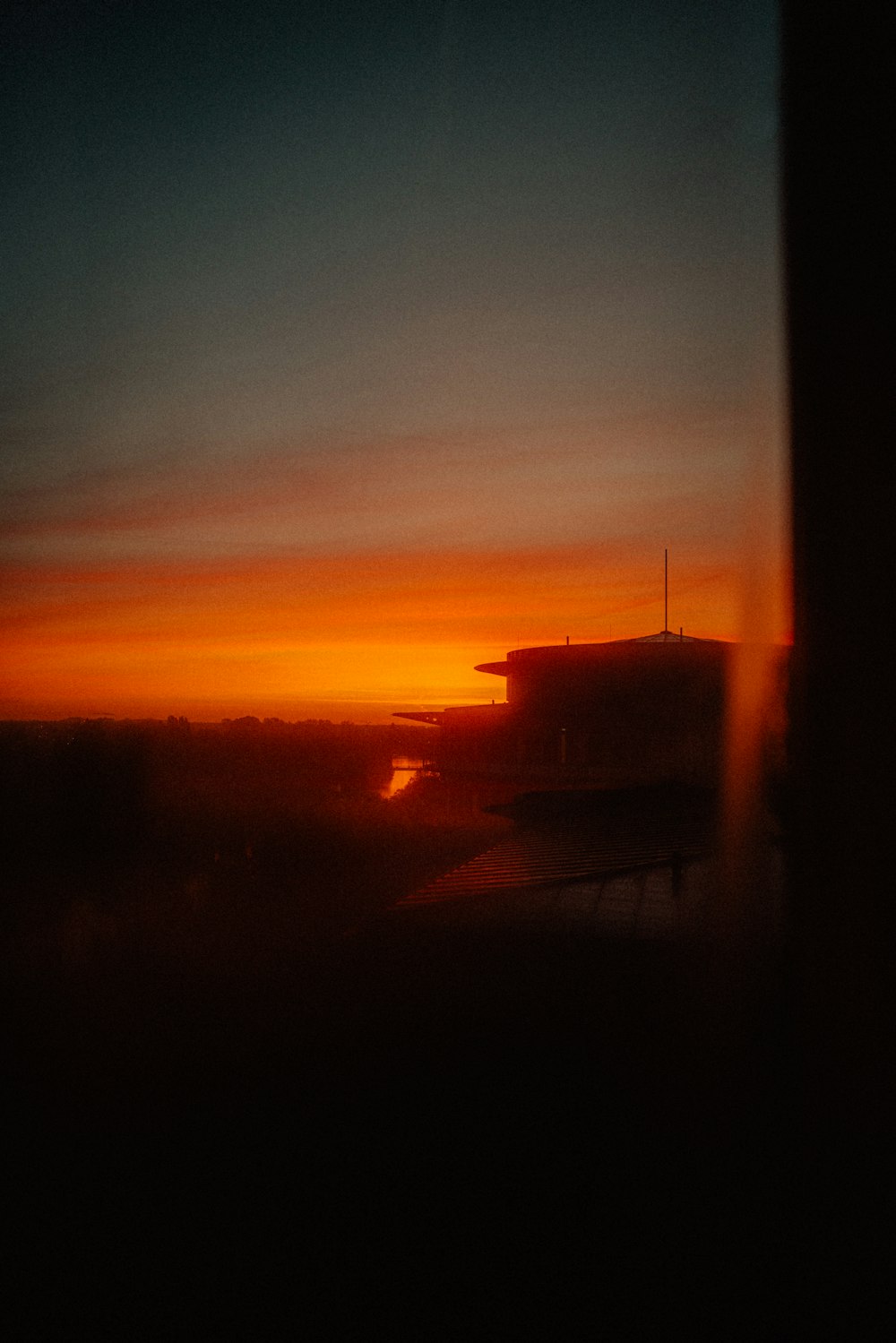 the sun is setting behind a building