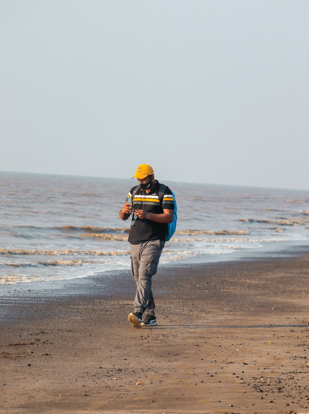 a man walking on the beach with a surfboard