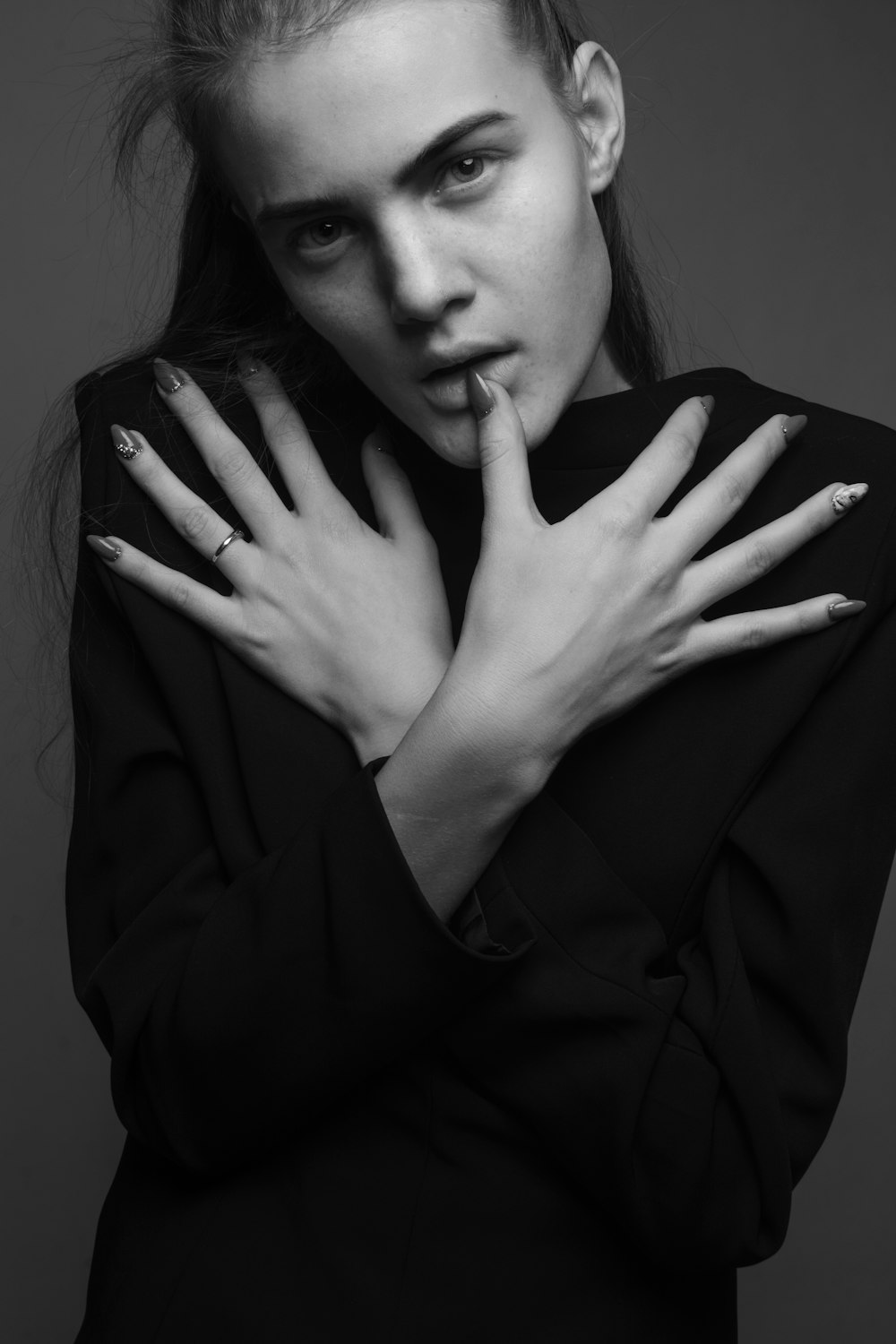 a black and white photo of a woman with her hands on her face