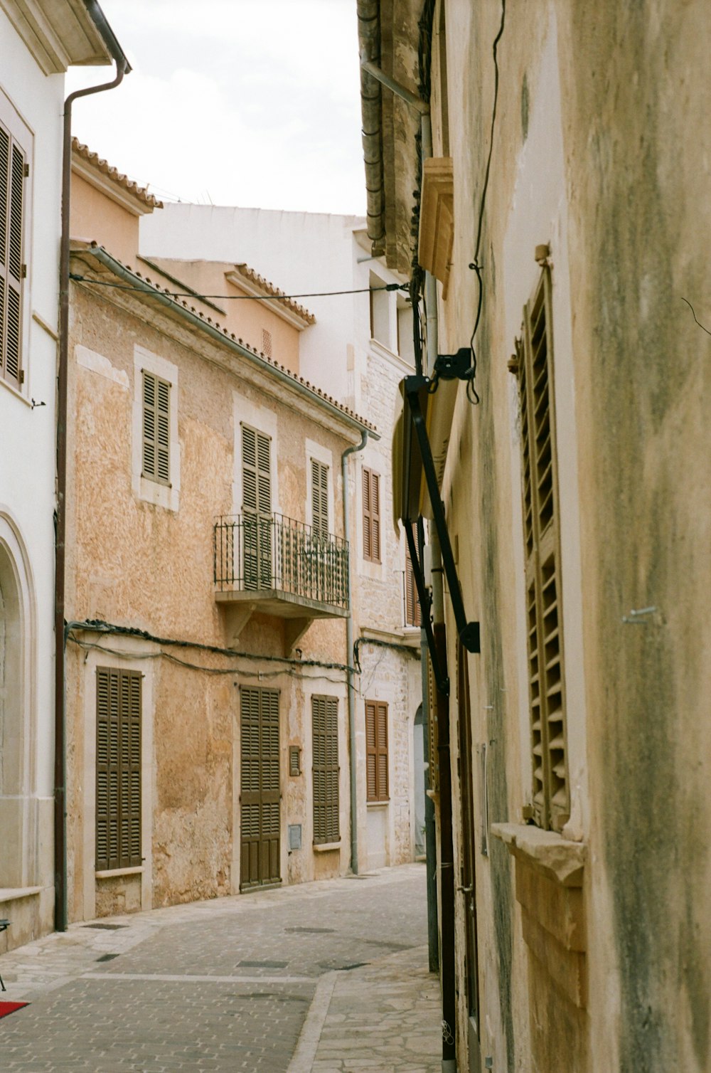 a narrow alley way with a red umbrella