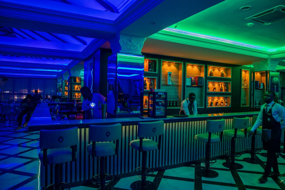 a man standing in front of a bar with neon lights