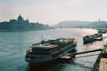 a large boat floating on top of a river next to a bridge