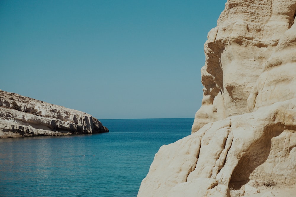 a large rock outcropping next to a body of water