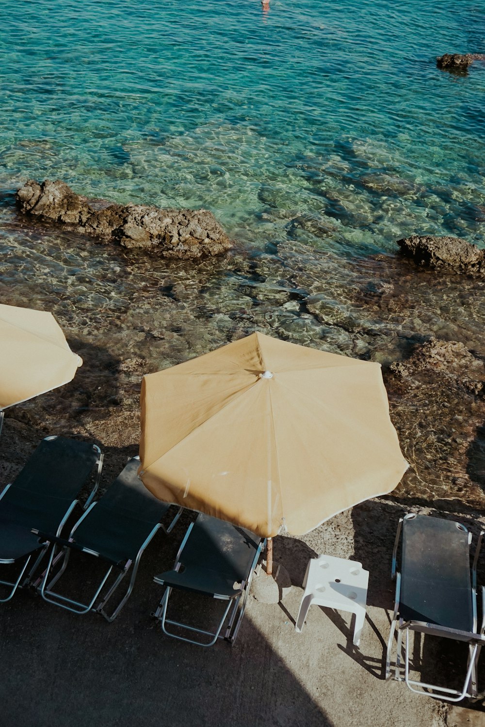 a couple of lawn chairs sitting next to a body of water