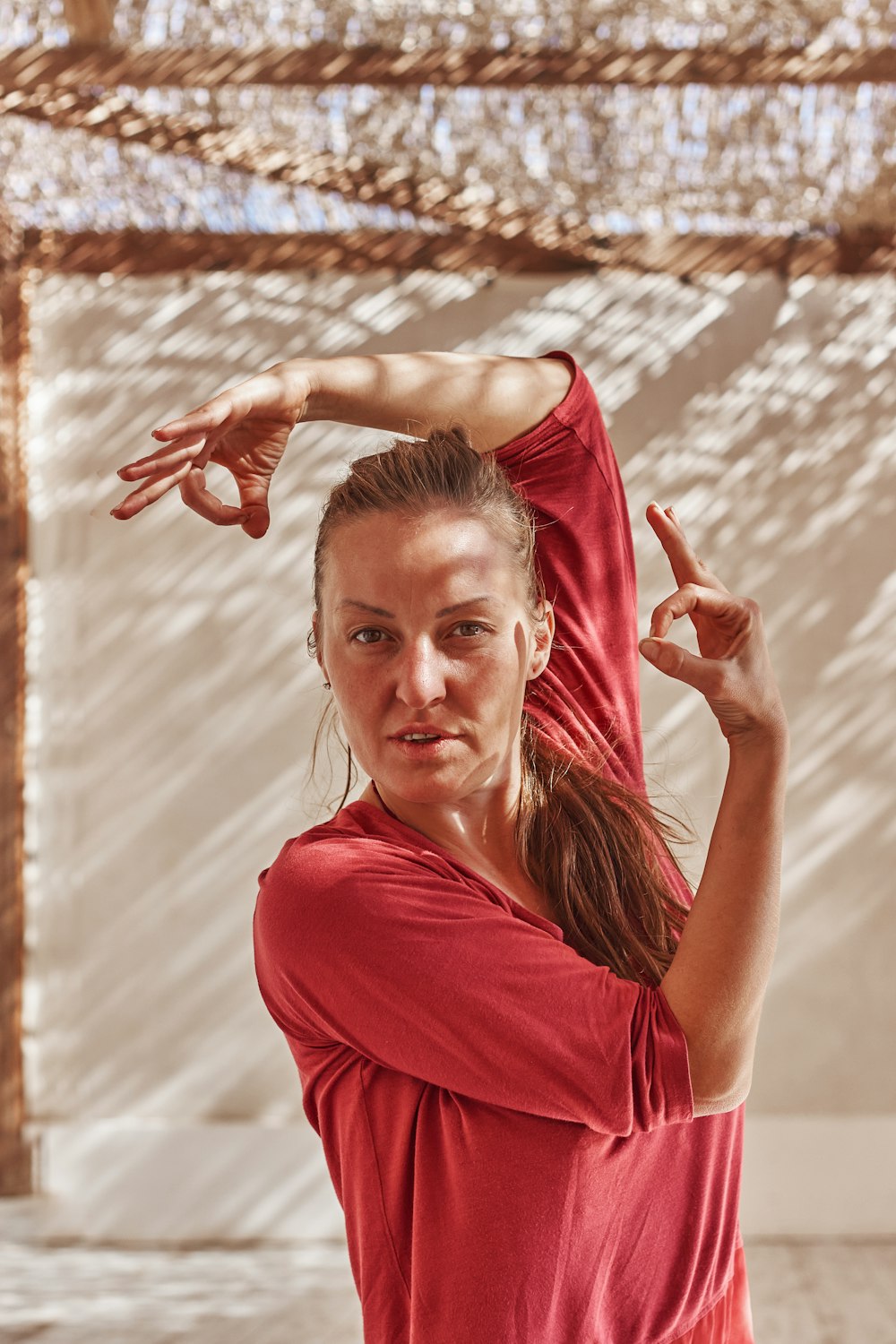 a woman in a red shirt doing a yoga pose