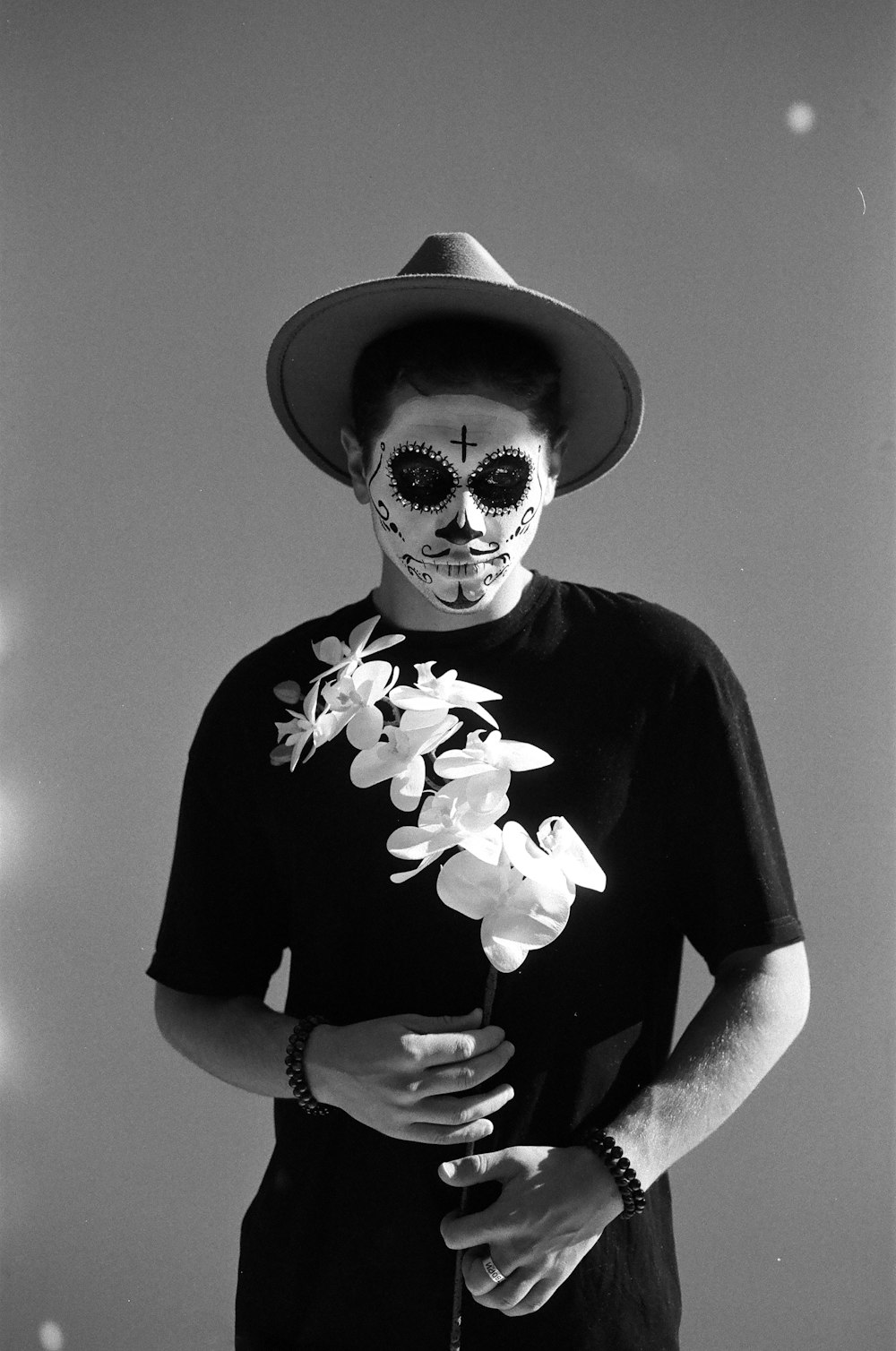 a man wearing a mask and flowers on his face