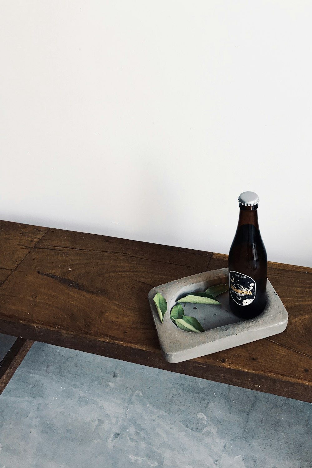 Una botella de cerveza encima de una mesa de madera