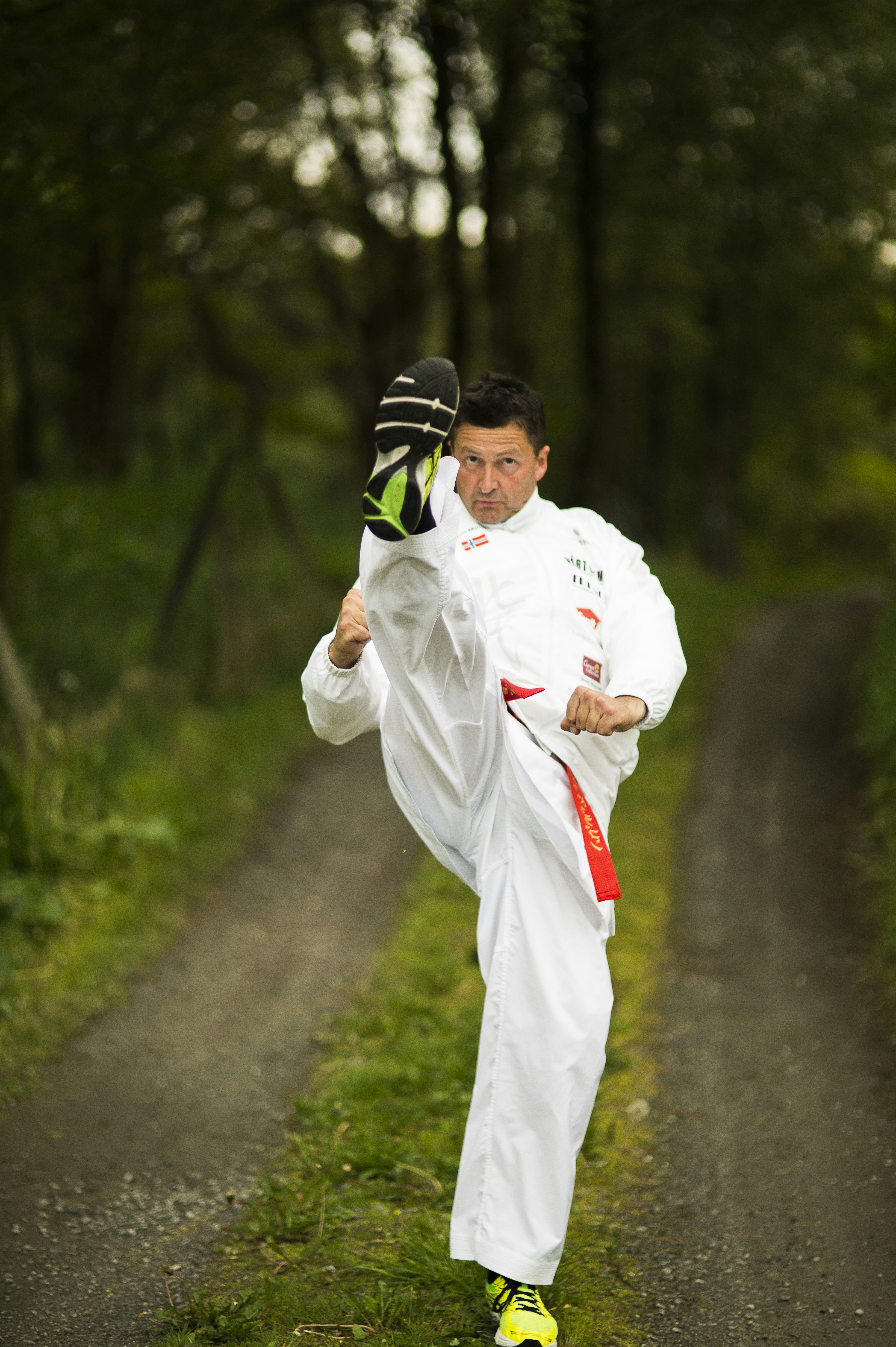 a man in a white suit kicking a soccer ball