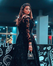 Elegant model showcasing a sleek black evening dress under soft lighting capturing luxury and refinement.