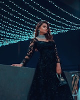 An elegant evening look with a fitted black dress accented by subtle shimmer and minimalist accessories.