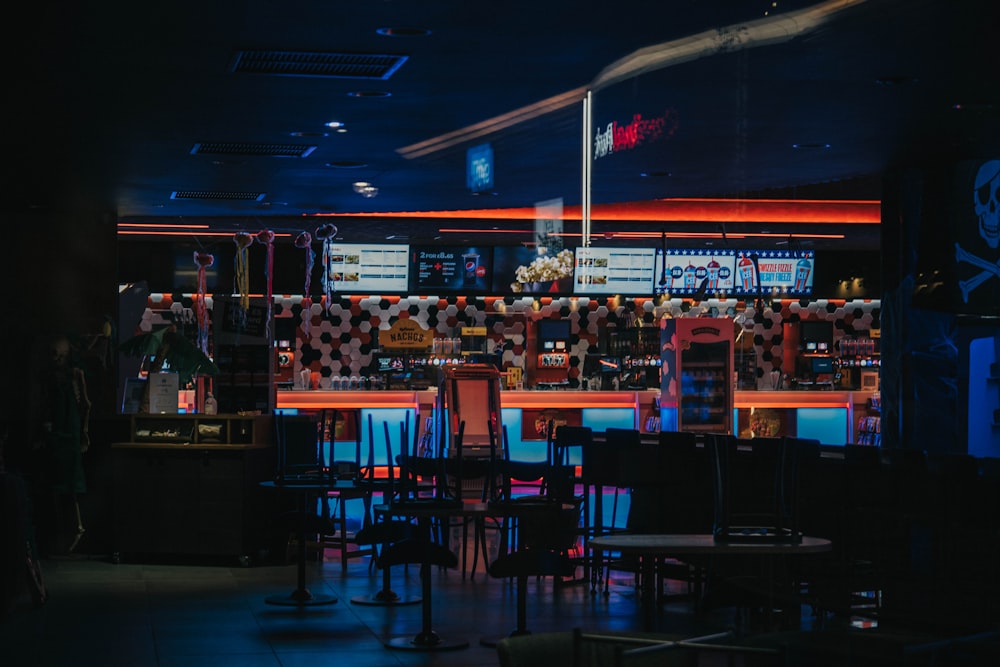 a dimly lit bar with a lot of tables and chairs