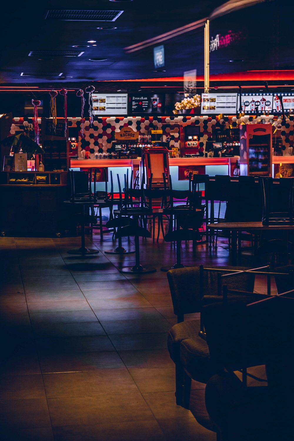 a dimly lit restaurant with tables and chairs