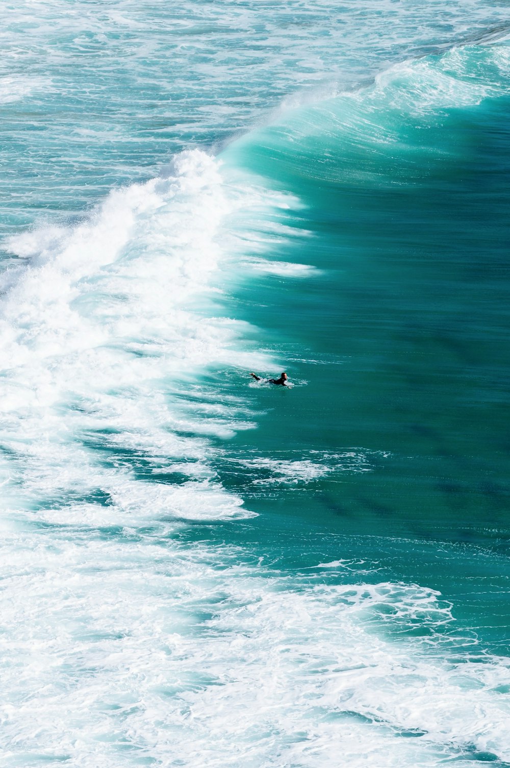 a man riding a wave on top of a surfboard