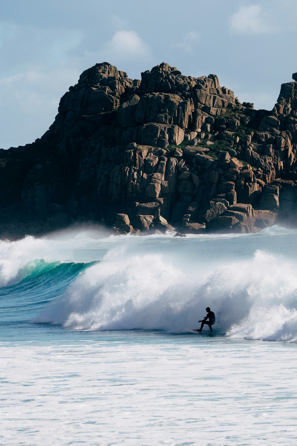 a man riding a wave on top of a surfboard