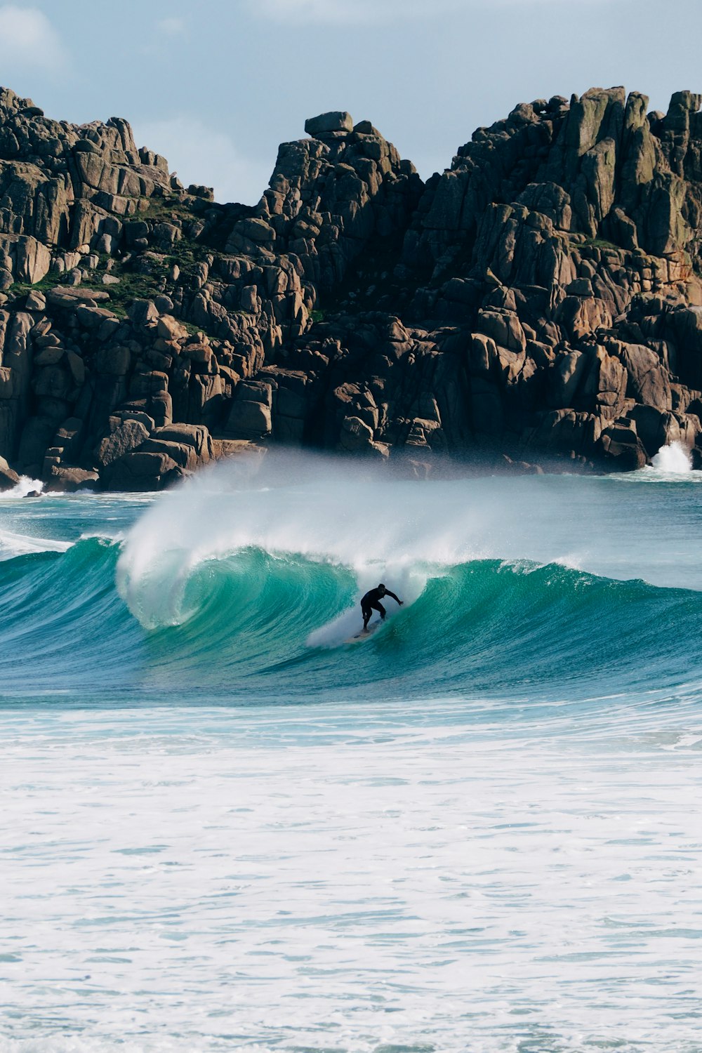 a man riding a wave on top of a surfboard