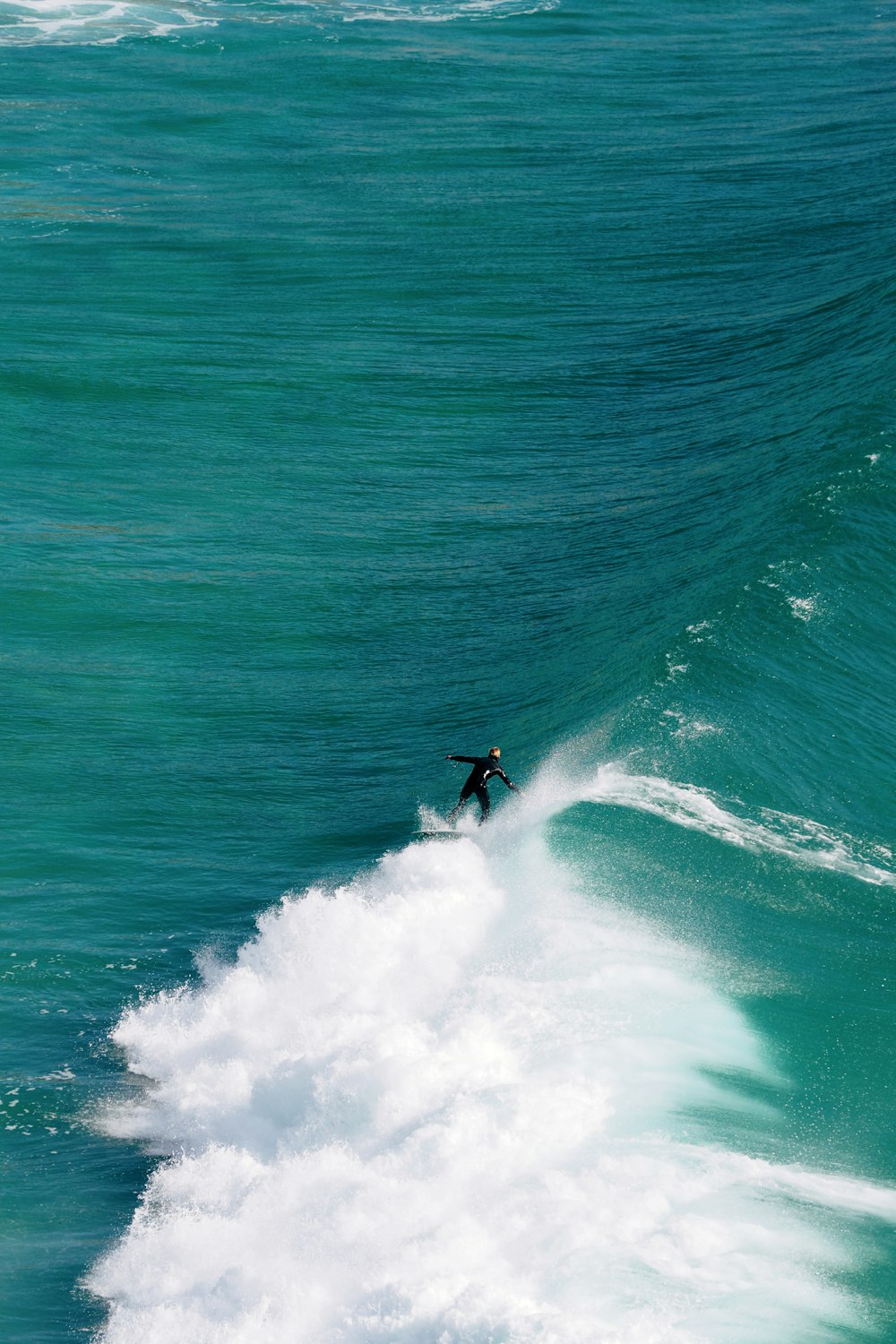 a man riding a wave on top of a surfboard