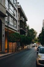 a car parked on the side of a street next to a tall building