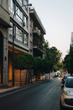 a car parked on the side of a street next to a tall building