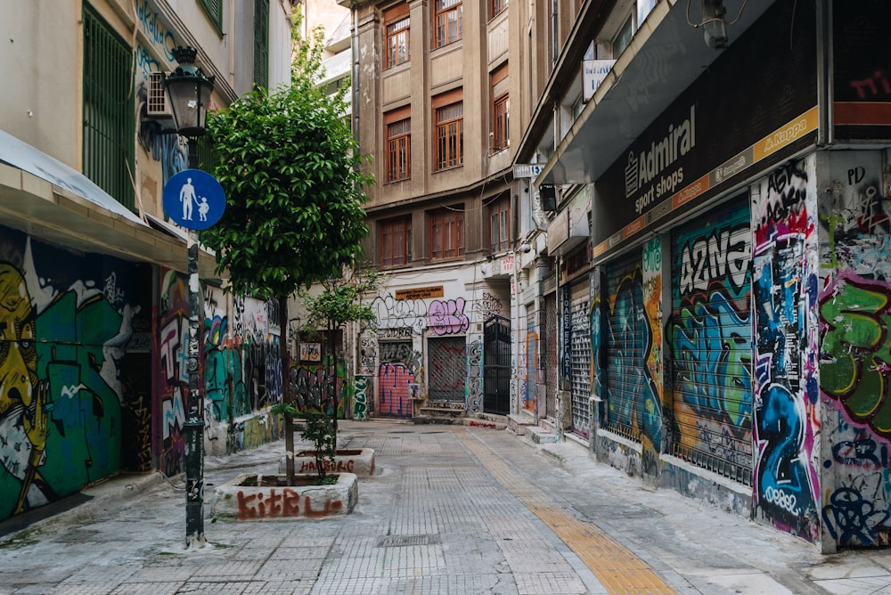 a narrow street with graffiti all over it