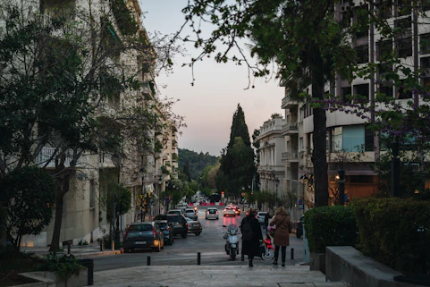 a group of people walking down a street next to tall buildings