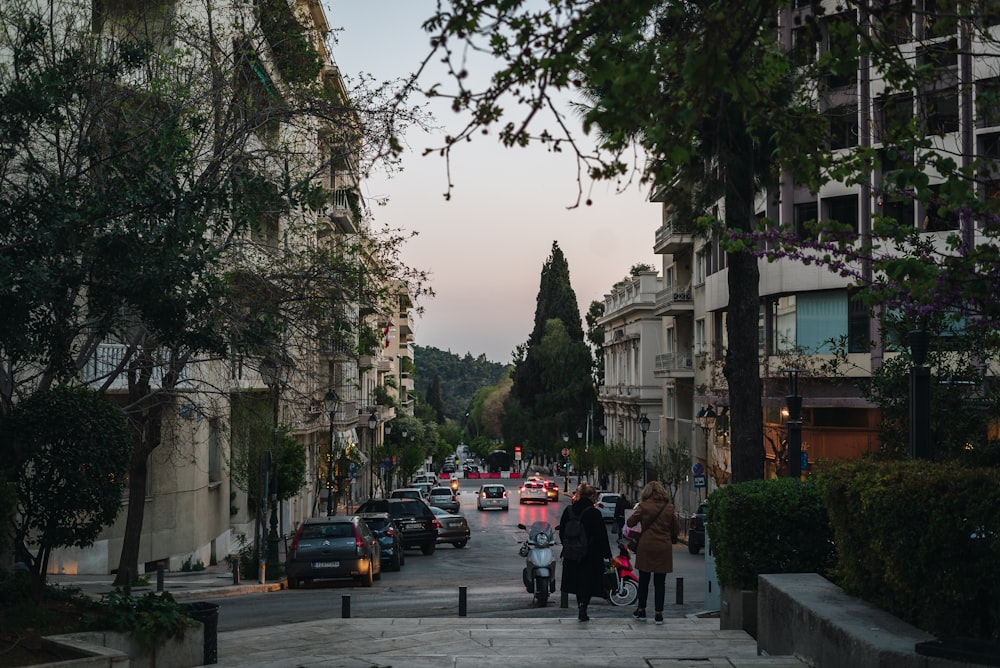 a group of people walking down a street next to tall buildings