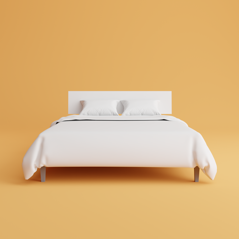 una cama con una funda blanca y almohadas encima