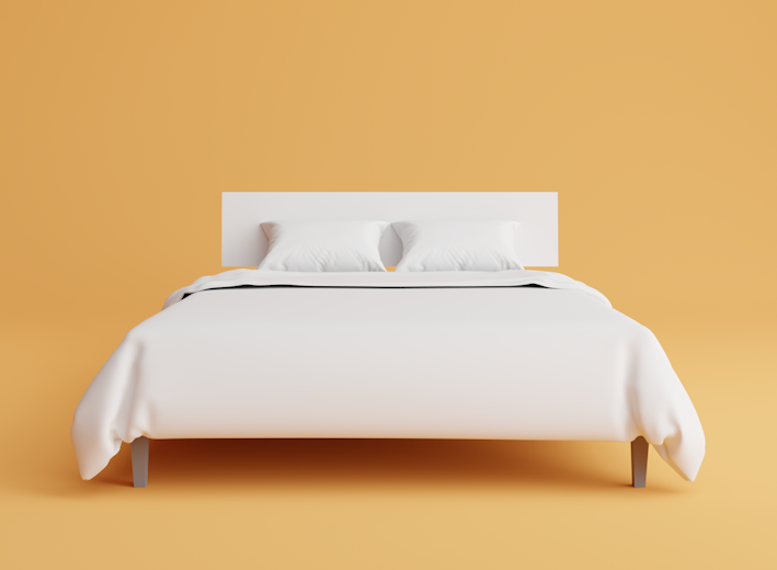 a bed with a white cover and pillows on top of it