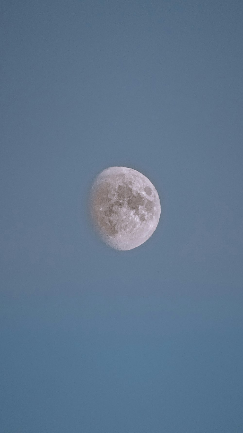 a full moon in a clear blue sky