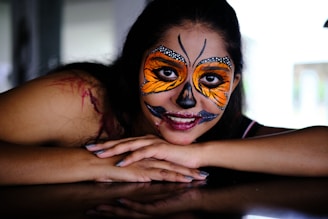 a woman with face paint laying on a table