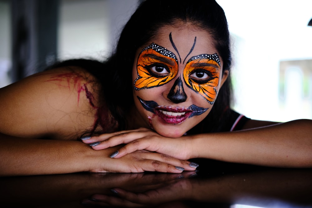 a woman with face paint laying on a table