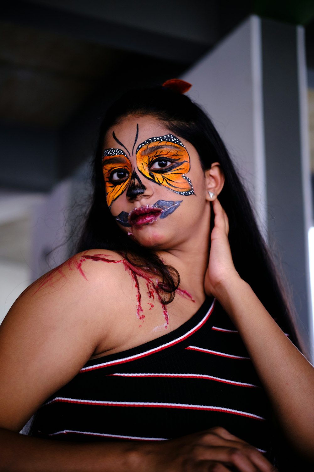 a woman with a painted face and butterfly on her face