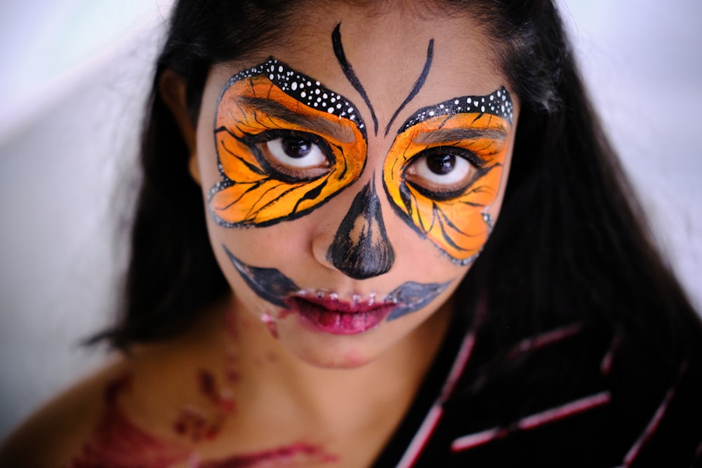 a young girl with a butterfly painted on her face