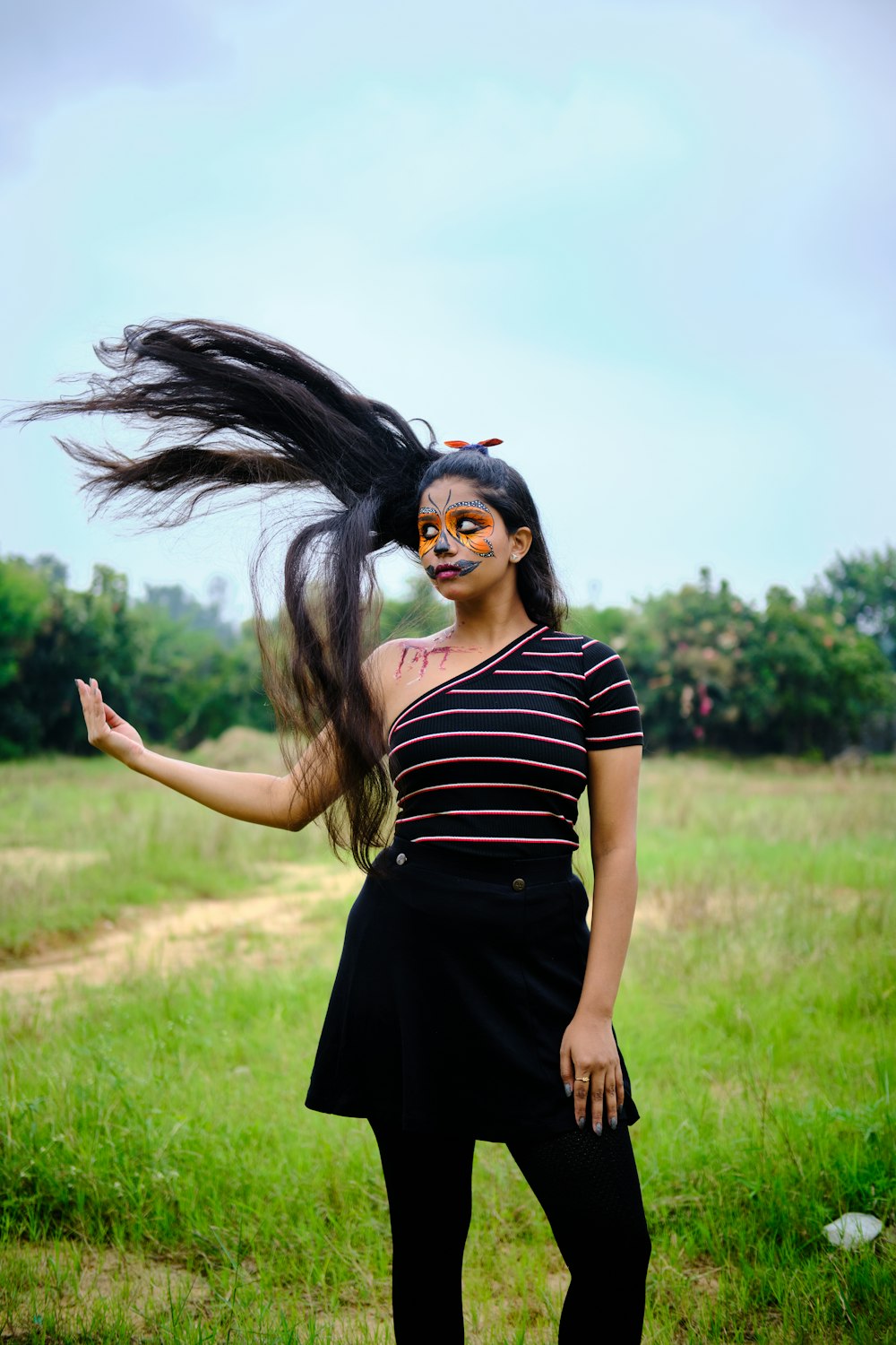 a woman standing in a field with her hair blowing in the wind