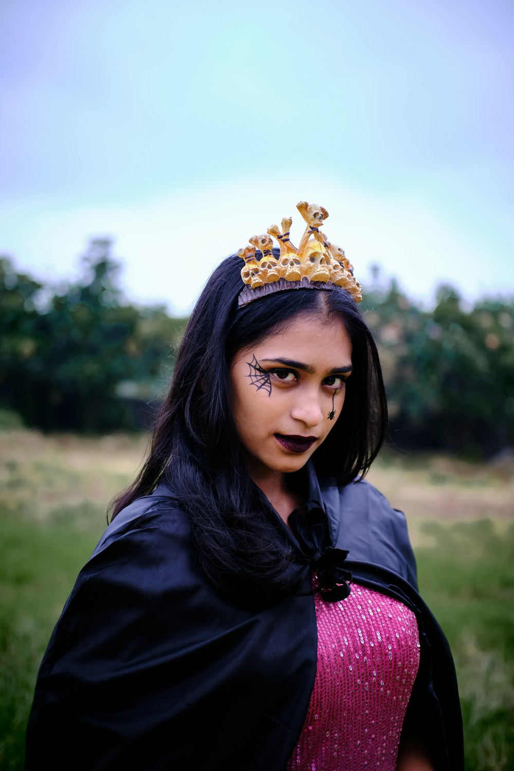 a young girl wearing a crown and a cape