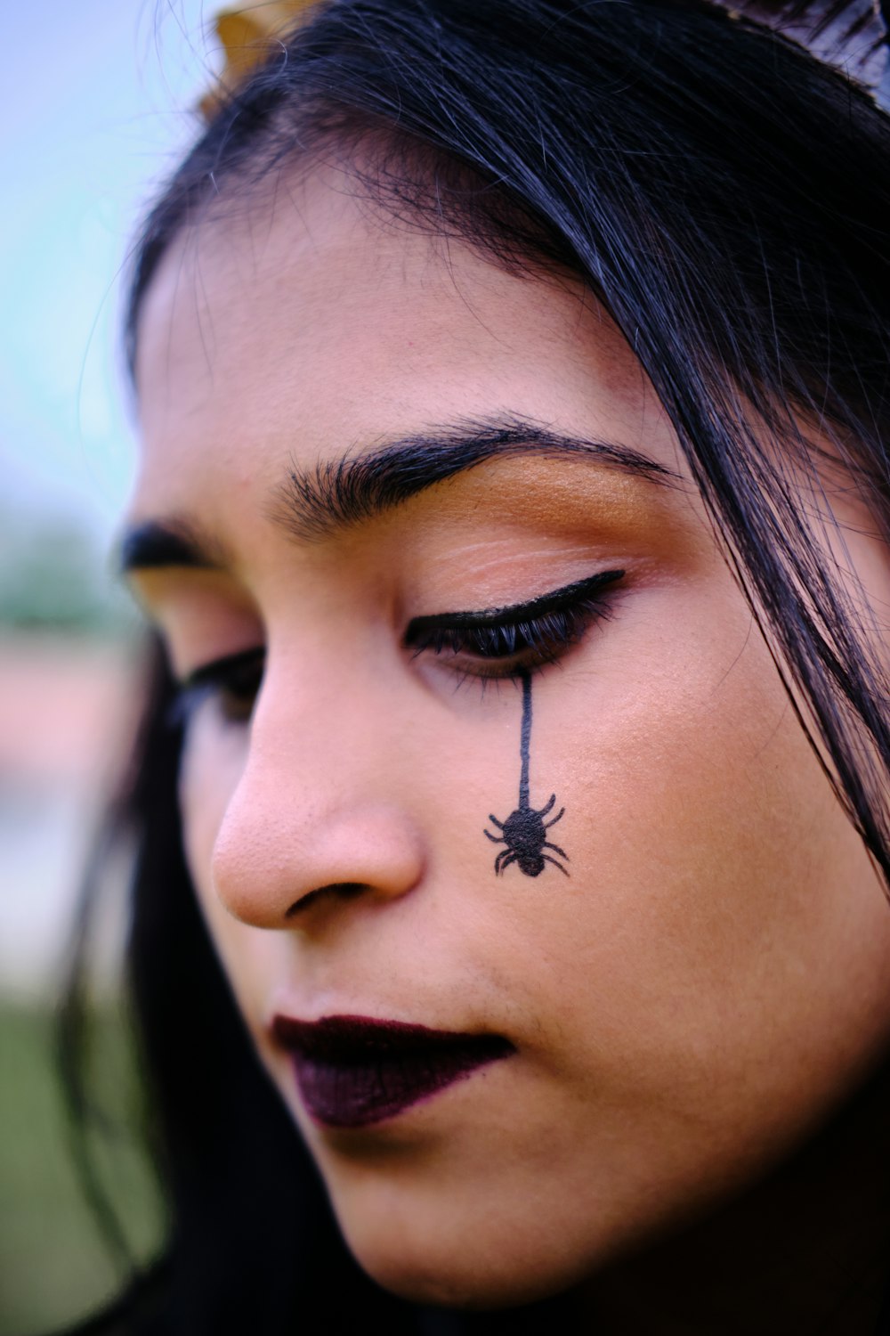 a woman with a spider on her forehead