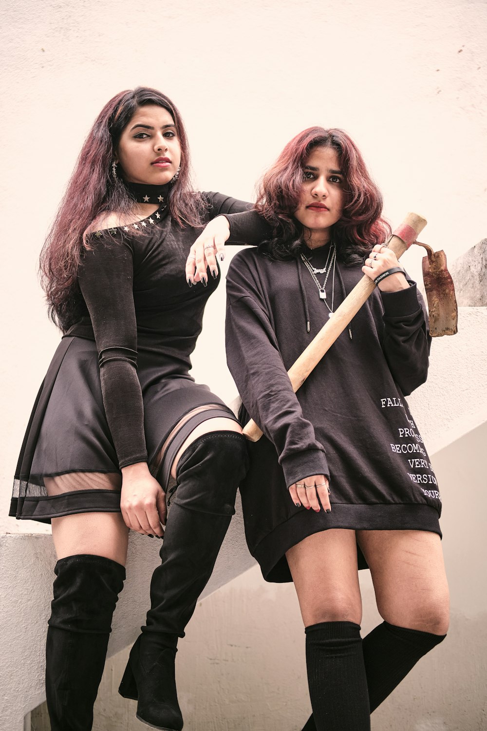 Zwei schwarz gekleidete Frauen posieren für ein Foto