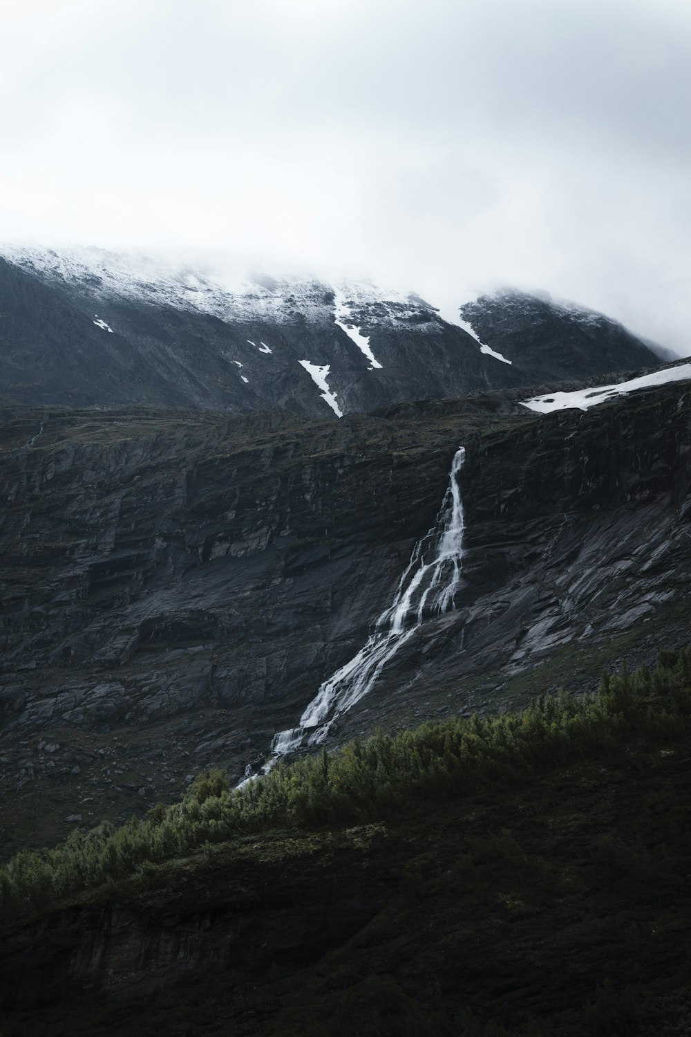 a very tall mountain with a small waterfall