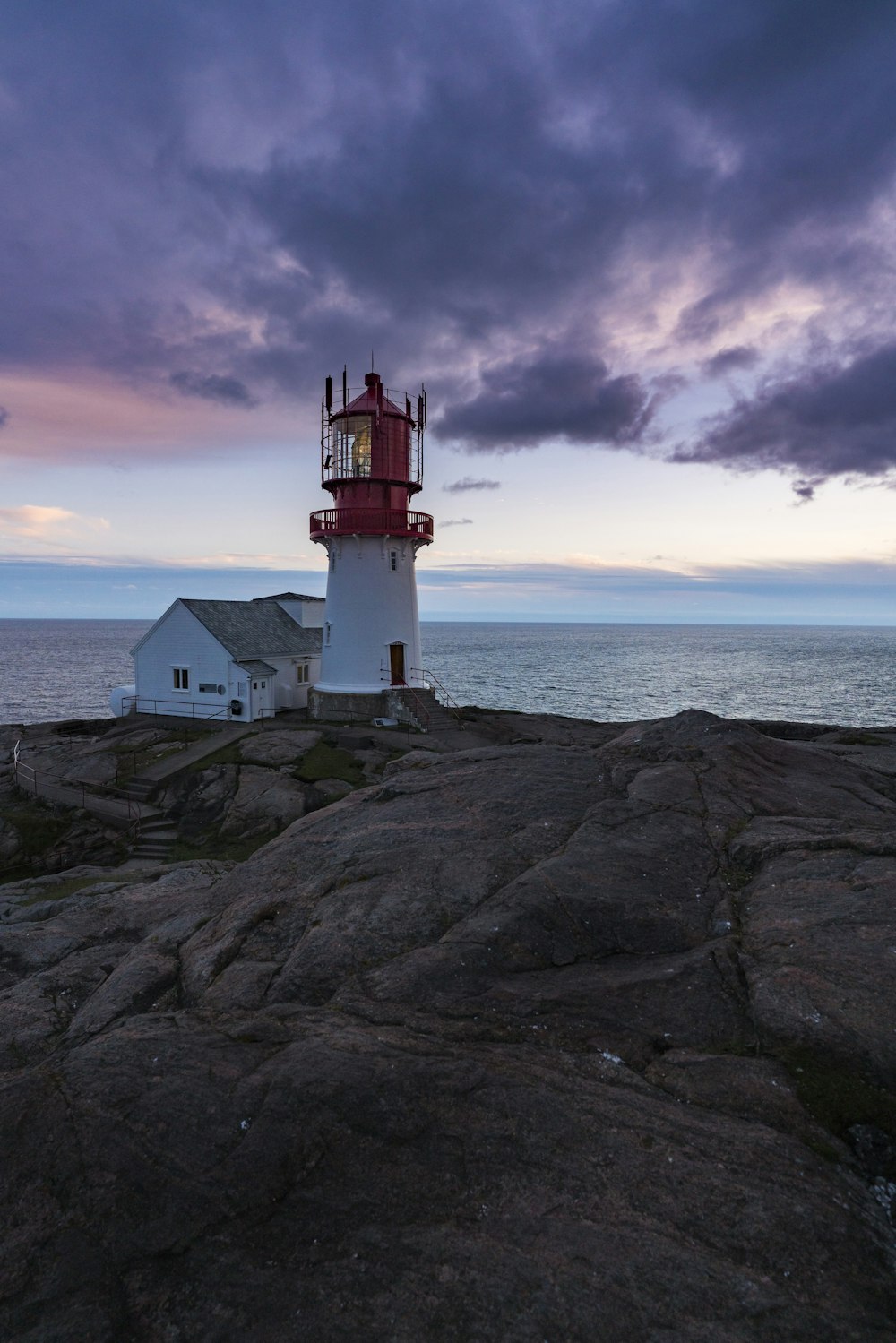 a red and white lighthouse sitting on top of a rock