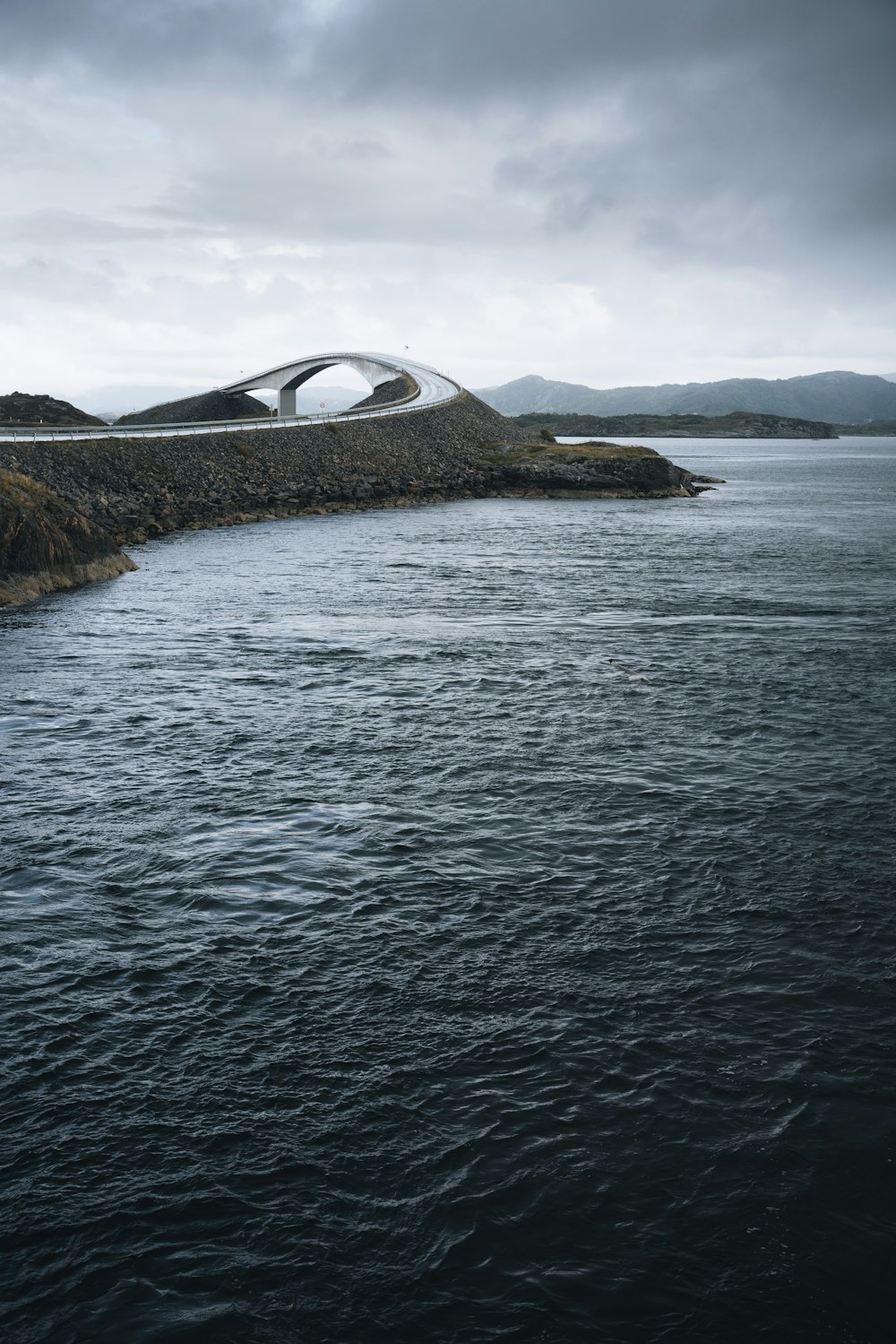 a bridge over a body of water under a cloudy sky