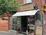 Charming shop front on a bustling Montreal street with colorful signage.
