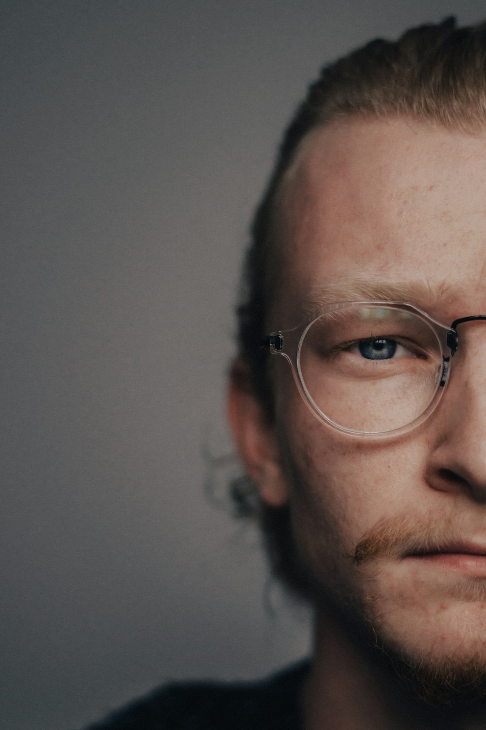 a man with glasses and a beard looks at the camera