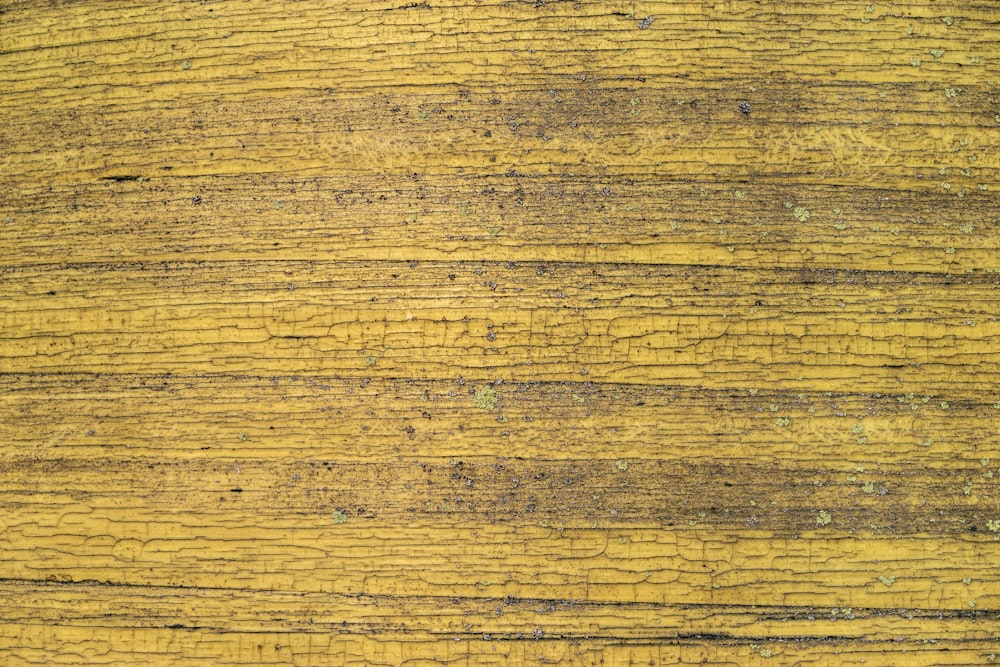 a close up of a wooden surface with yellow paint