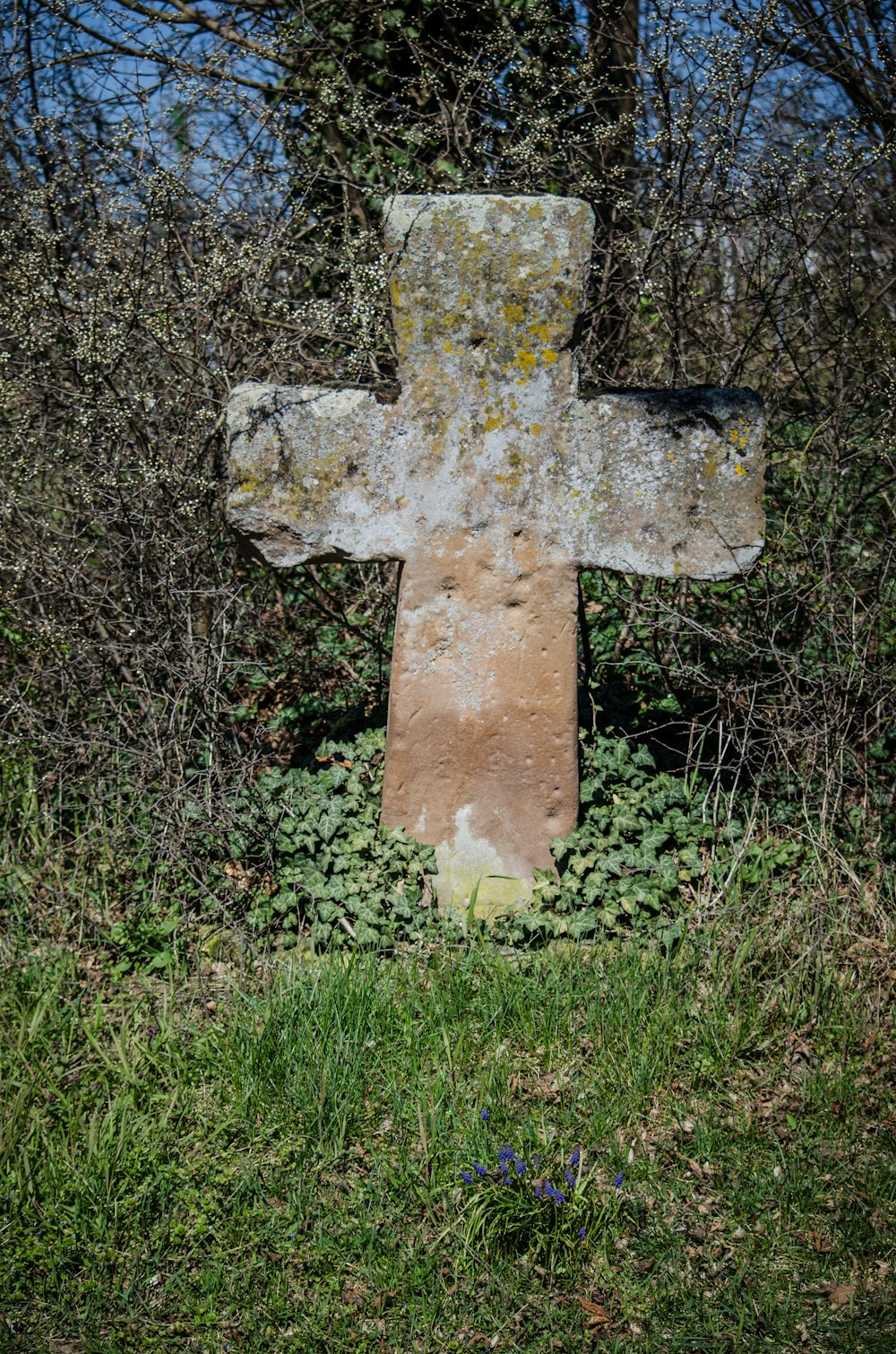 a large stone cross sitting in the middle of a field